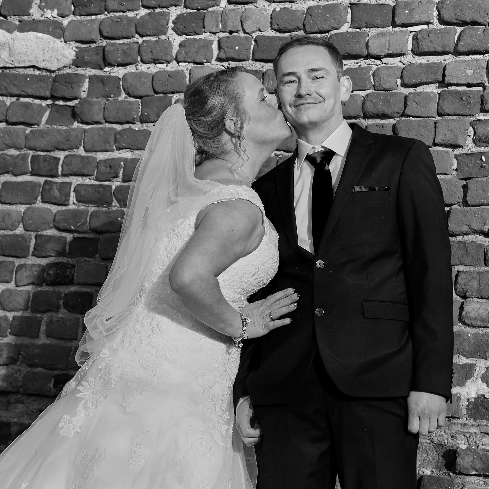Foto Brautpaar Shooting Braut und Bräutigam Großaufnahme Braut steht und küsst